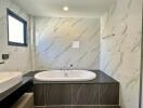 Modern bathroom with large bathtub and marbled walls