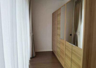 Closet area with wooden floor and large mirrored wardrobes in a bedroom