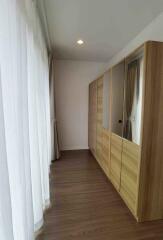 Closet area with wooden floor and large mirrored wardrobes in a bedroom