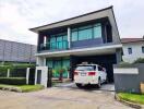 Modern two-story house with driveway and car