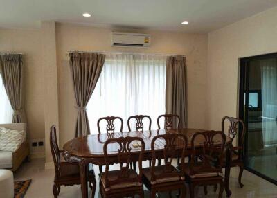 Elegant dining area with a large wooden table and chairs, adjacent to living space