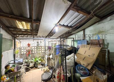 A cluttered utility room with various household items and boxes