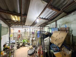 A cluttered utility room with various household items and boxes