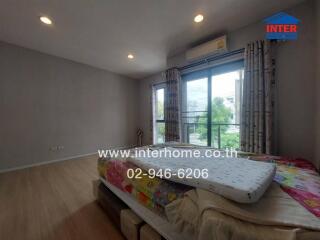 Spacious bedroom with large window and balcony access