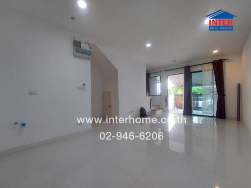 Bright and spacious living room with large windows and balcony access