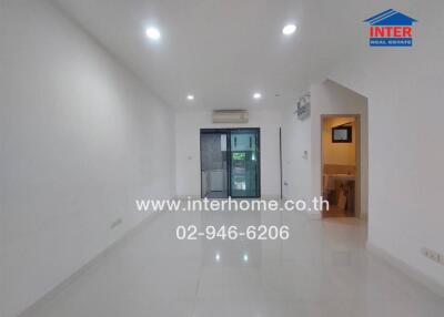 Empty living space with glossy tiled floor and recessed lighting