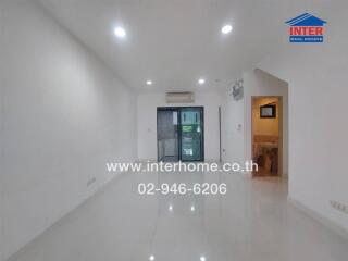 Empty living space with glossy tiled floor and recessed lighting