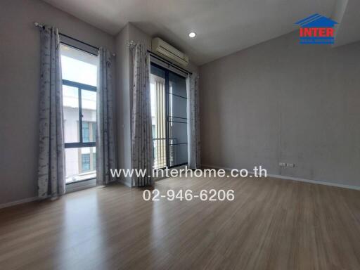 Bedroom with wooden flooring and large windows