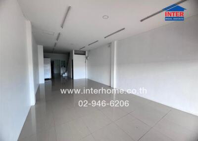 Spacious empty commercial space with tiled flooring and white walls