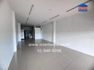 Spacious empty commercial space with tiled flooring and white walls