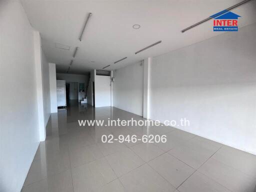 Spacious empty commercial space with tiled flooring and white walls