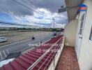 View from balcony overlooking a road and open area