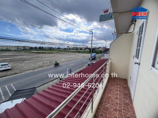 View from balcony overlooking a road and open area