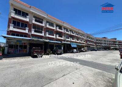 Exterior view of residential buildings with vehicles parked outside