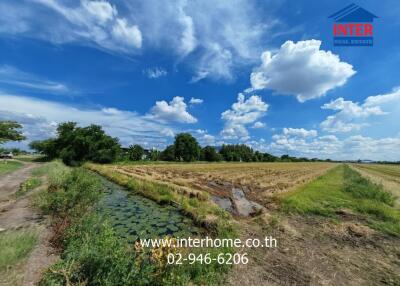 Expansive view of a rural property with open fields and a clear blue sky