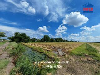 Expansive view of a rural property with open fields and a clear blue sky