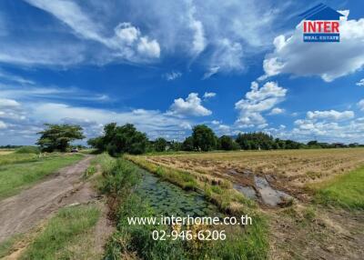 View of rural landscape with blue sky, greenery, and waterbody