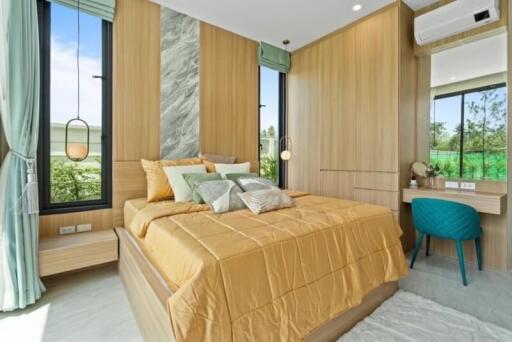 Modern bedroom with large bed, wooden wall paneling, ample natural light, and a small desk setup