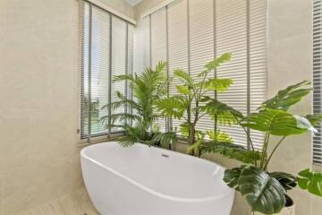 Modern bathroom with white bathtub and green plants