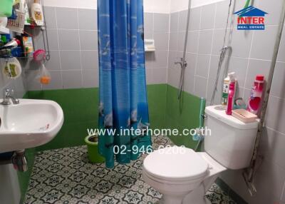 Modern bathroom with shower, sink, toilet, and vibrant blue shower curtain