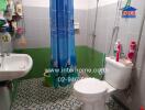 Modern bathroom with shower, sink, toilet, and vibrant blue shower curtain