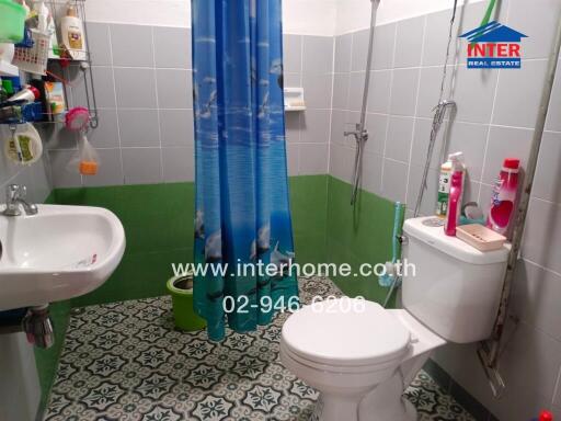 Modern bathroom with shower, sink, toilet, and vibrant blue shower curtain