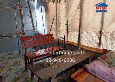 Covered outdoor area with wooden furniture and ladder