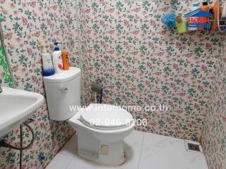 Bathroom with floral wallpaper and toilet