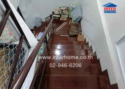 Staircase leading to an upper floor with storage items