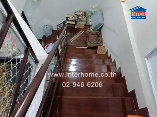 Staircase leading to an upper floor with storage items