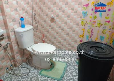 Bathroom with shower, toilet, and storage bin