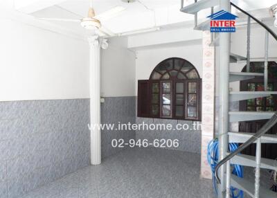 Spacious main living area with a spiral staircase, large windows, and tiled flooring