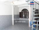 Spacious main living area with a spiral staircase, large windows, and tiled flooring