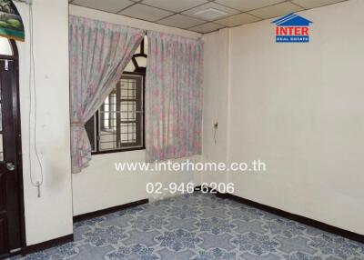 Empty bedroom with floral curtains and tiled floor