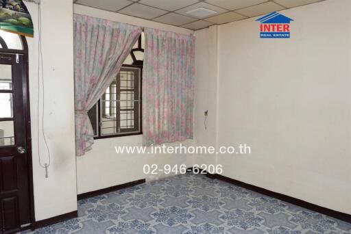 Empty bedroom with floral curtains and tiled floor