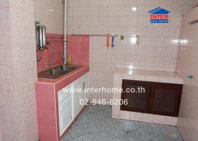 Small kitchen with dual sinks and tiled walls