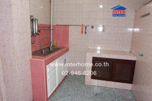 Small kitchen with dual sinks and tiled walls