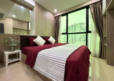 Modern bedroom with large window and red bedding