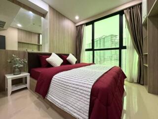 Modern bedroom with large window and red bedding