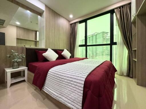 Modern bedroom with large window and red bedding