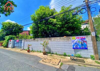 Exterior view of a property with a wall, trees, and a 