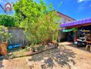 Spacious outdoor area with plants and a covered parking spot