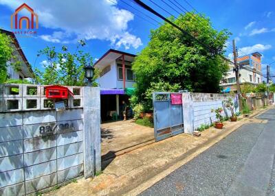 Front view of a residential building with a gated entrance and pathway