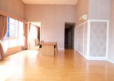 Well-lit dining area with hardwood floors and wooden dining set