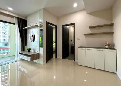 Modern living area with glass partition, cabinet storage, and shelving