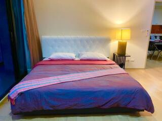 Modern bedroom with a large bed, two pillows, and a bedside lamp