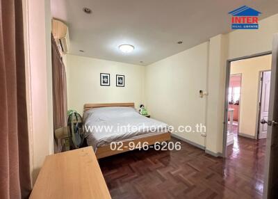 Bedroom with a large bed, dresser, air conditioning, and parquet flooring