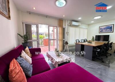 Spacious living room with purple couch and large windows