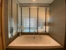 Bathroom with bathtub and window blinds