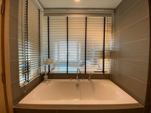 Bathroom with bathtub and window blinds